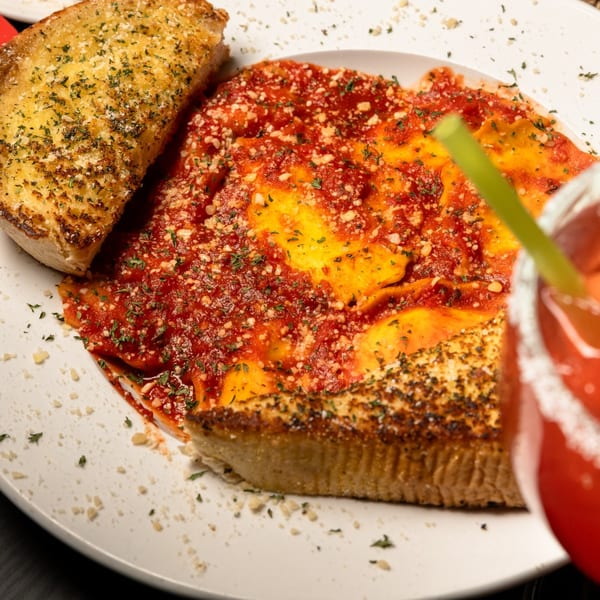 Gusto Dolce Italian Bistro's ravioli with red sauce, garlic bread, and a cocktail.